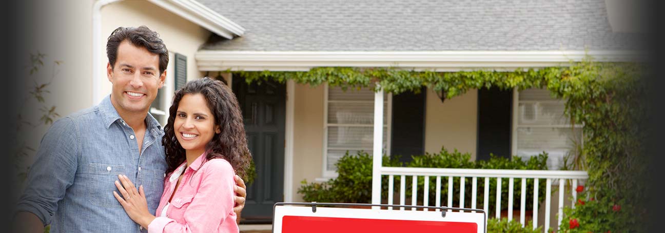 happy couple in front of house after selling annuity payments for cash and get settlement money.