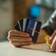 Young man cutting credit card with scissors due to debt.