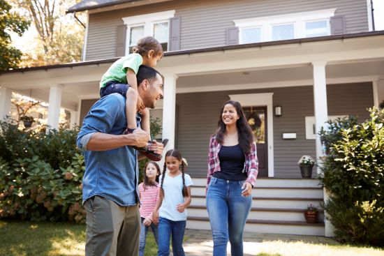 happy family in front of home with no mortgage debt