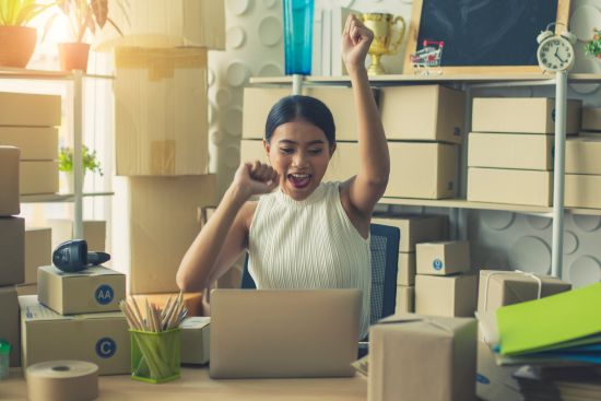 happy woman entrepreneur cheering after a successful business day