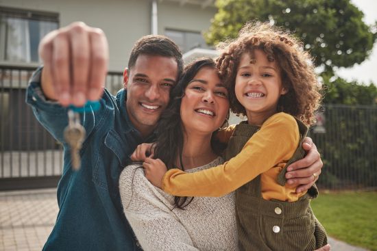 Happy multi-generational family sitting together on a couch, enjoying financial security after selling a structured settlement.
