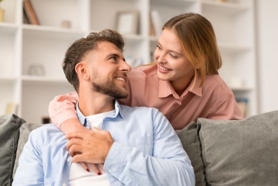Happy multi-generational family sitting together on a couch, enjoying financial security after selling a structured settlement.
