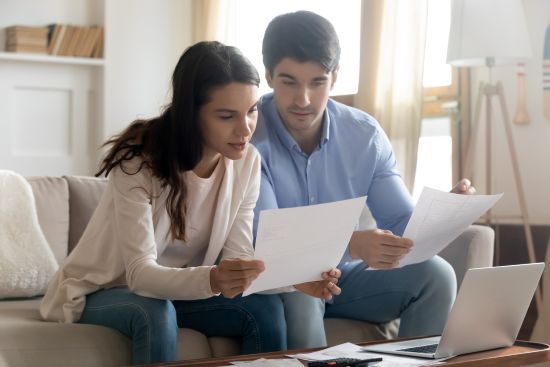 Couple reviewing documents together on couch while researching what are structured settlements and payment options