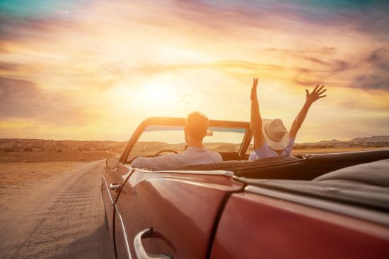 Couple driving convertible into the sunset celebrating financial freedom after choosing a lump sum settlement option