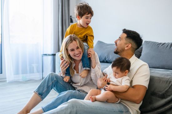 Couple smiling at laptop in bright kitchen while learning the steps to sell structured settlement for immediate cash