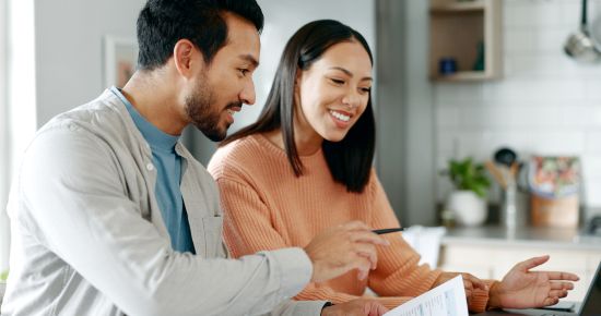 Couple reviewing paperwork at kitchen table while discussing options for taking money out of an annuity