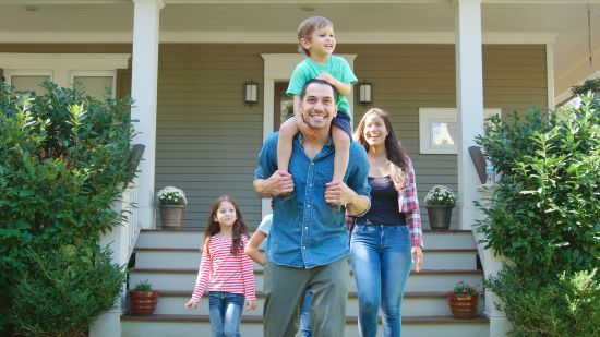 Happy family walking outside their home after gaining financial stability by understanding what are structured settlements