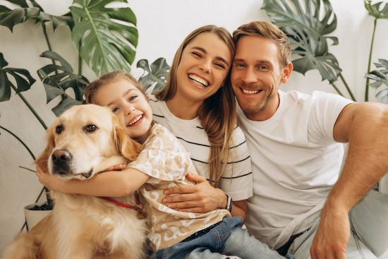 Cheerful family with golden retriever relaxing together after benefiting from learning what are structured settlements