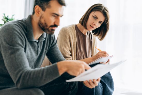 couple reviewing financial paperwork while considering selling structured settlement payments for cash